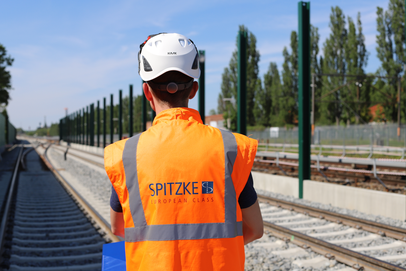 Ein Mitarbeiter in Warnweste ist im Gleis unterwegs.