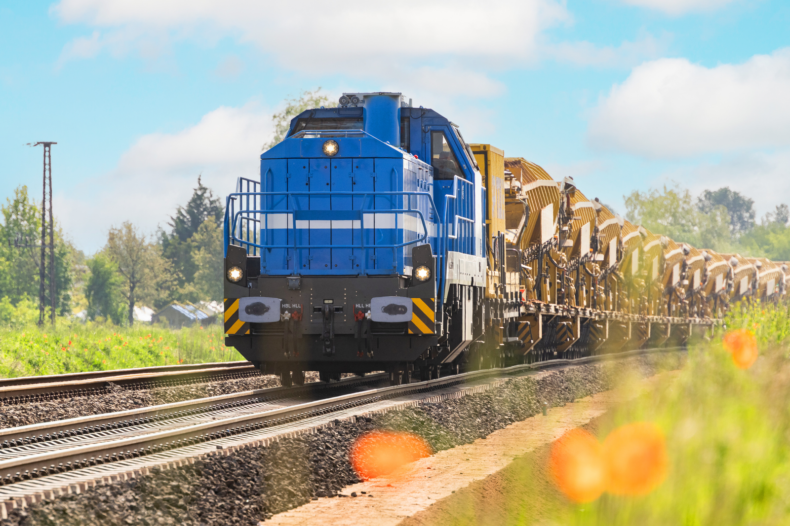 Ein Triebfahrzeug fährt mit MFS-Wagen auf dem Gleis entlang.