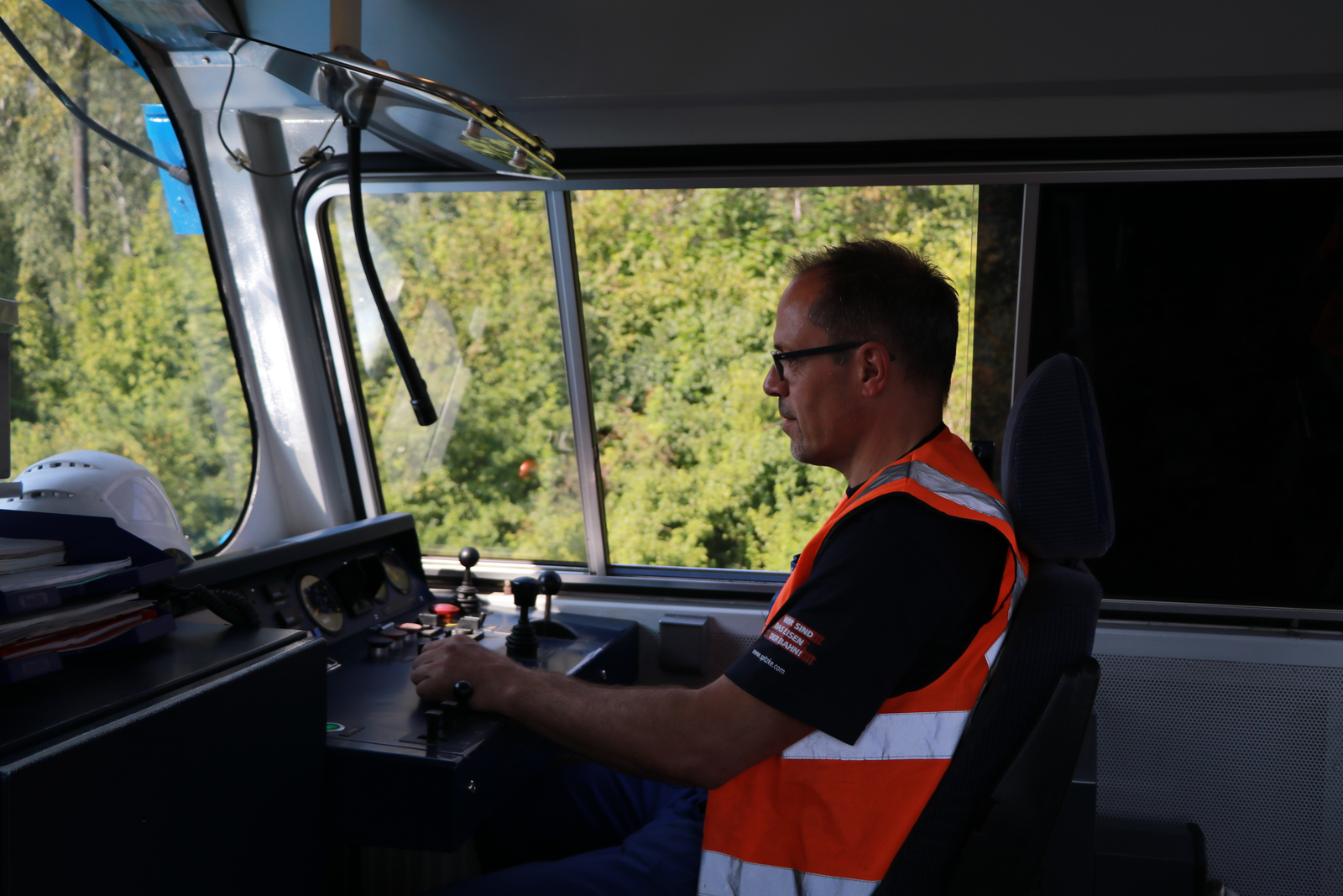 Ein Mitarbeiter sitzt im Führerstand einer Lok.